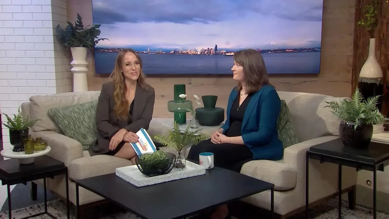 Crystal Tate on the KING 5 New Day Northwest set with the Seattle skyline behind her
